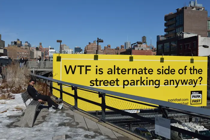 A photo of a billboard reading "WTF is alternate side of the street parking anyway?"